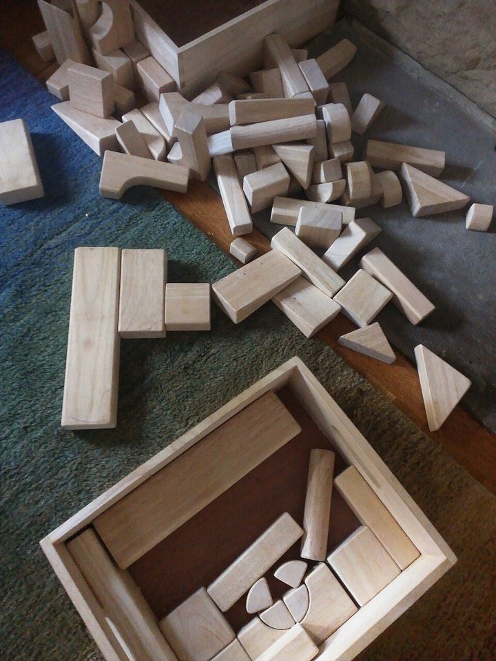 Wooden building blocks scattered on a carpet