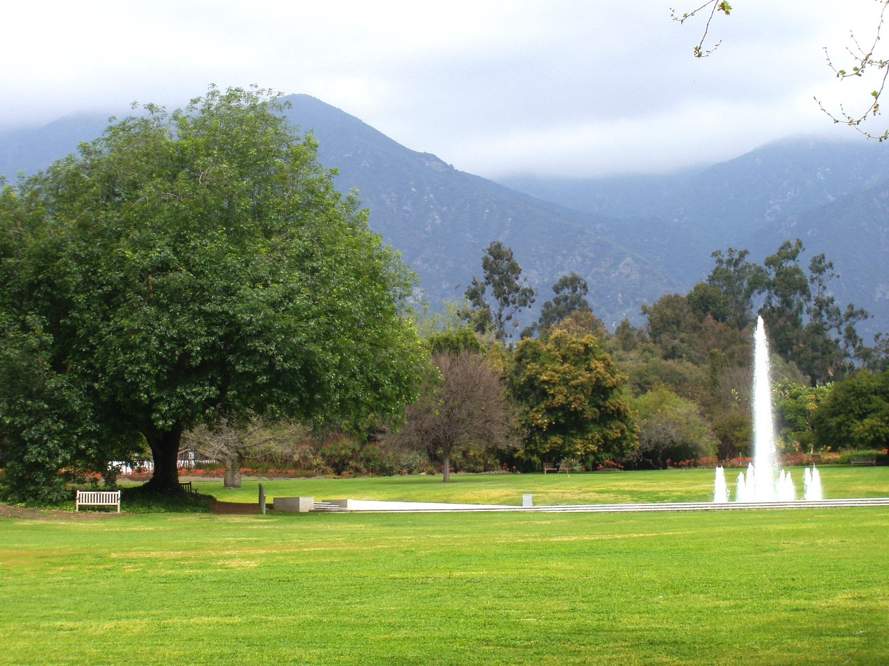 Fountain and lawn at the Los Angeles County Arboretum with mountains beyond